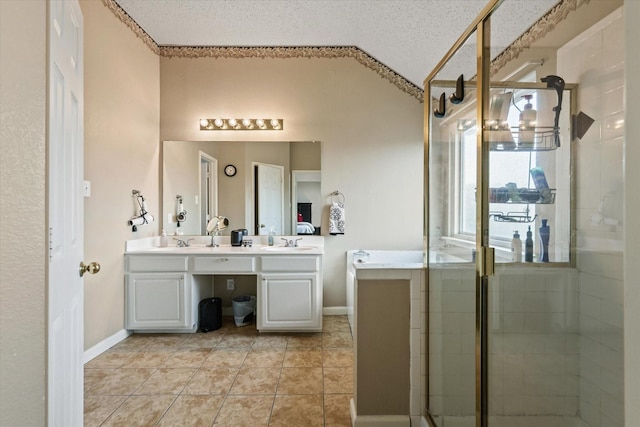 bathroom featuring double vanity, a shower stall, a sink, and tile patterned floors