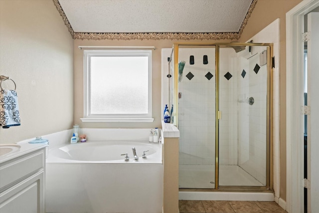 bathroom with a textured ceiling, tile patterned flooring, a garden tub, vanity, and a stall shower