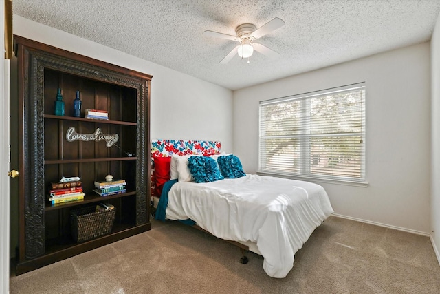 carpeted bedroom with ceiling fan and a textured ceiling