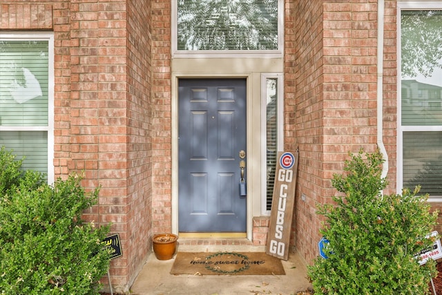 doorway to property with brick siding