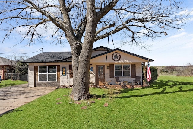 view of front of home featuring driveway, brick siding, and a front lawn