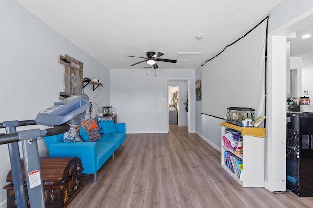 playroom featuring a ceiling fan, baseboards, and wood finished floors