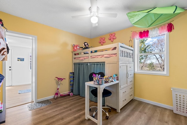 bedroom featuring ceiling fan, wood finished floors, and baseboards