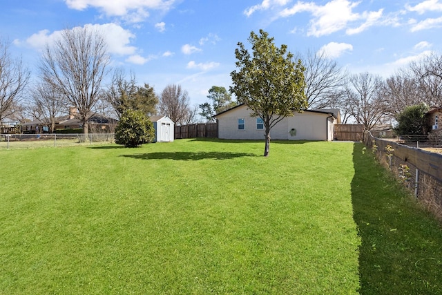 view of yard featuring a fenced backyard, an outdoor structure, and a storage unit