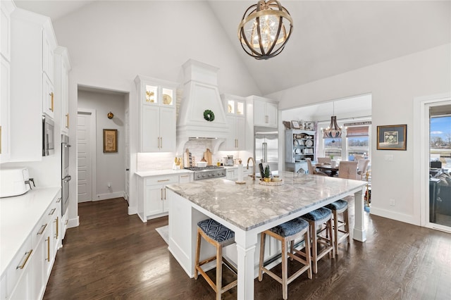 kitchen featuring a chandelier, dark wood-style floors, a kitchen breakfast bar, and custom range hood