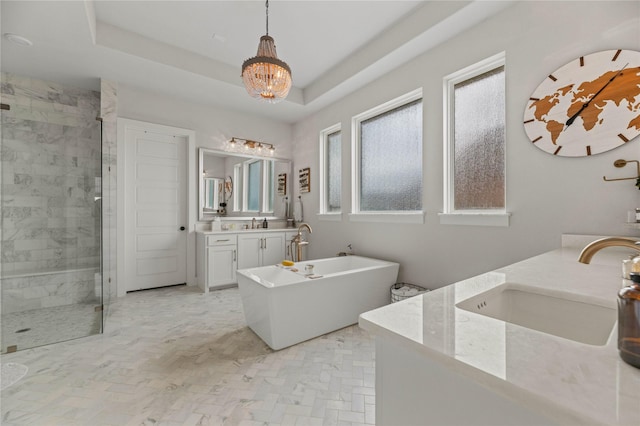 full bathroom featuring a tray ceiling, a soaking tub, a stall shower, and vanity