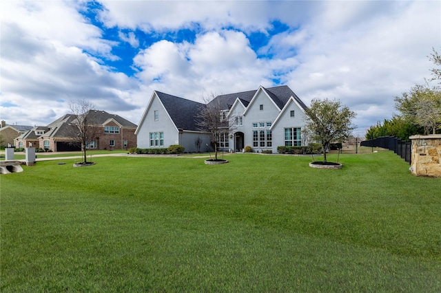 view of front of home with a front lawn and fence