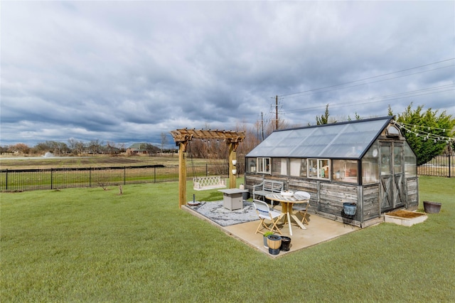 view of yard featuring a patio, an outdoor structure, fence, and an exterior structure