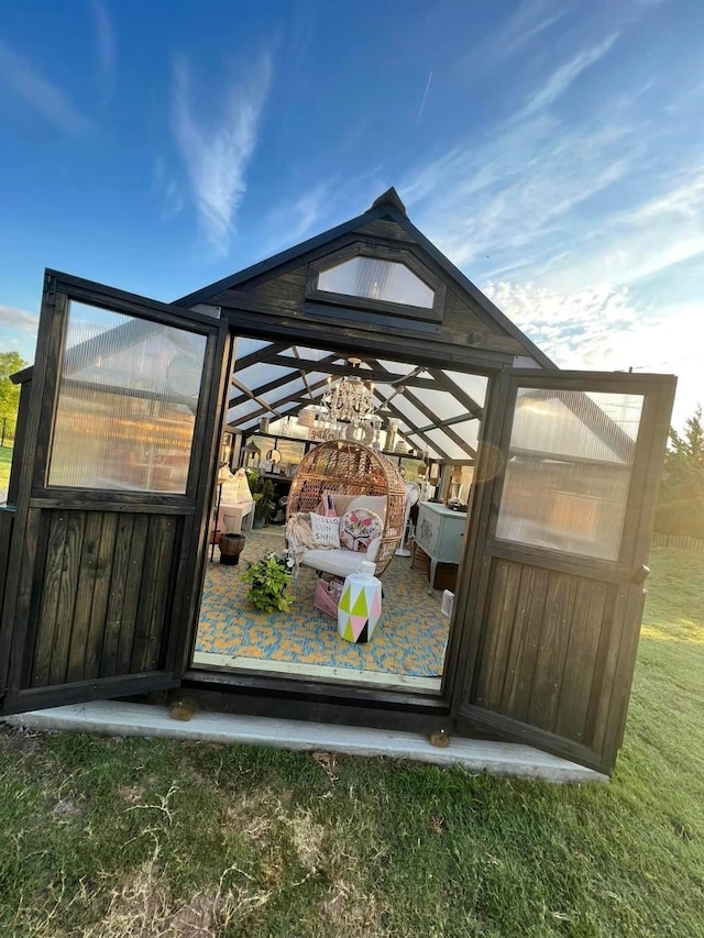 exterior space with a greenhouse and an outbuilding