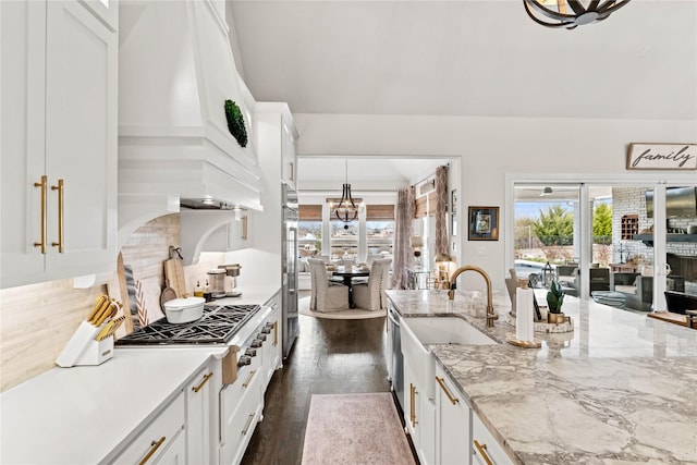 kitchen featuring premium range hood, stainless steel gas stovetop, dark wood-style floors, white cabinetry, and a sink