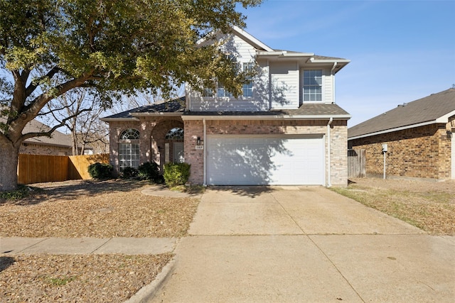 traditional home with driveway, a garage, fence, and brick siding