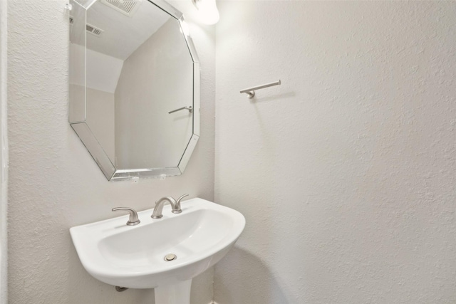 1153 Regal Dr, Garland, TX 75040 - bathroom featuring a sink and a textured wall