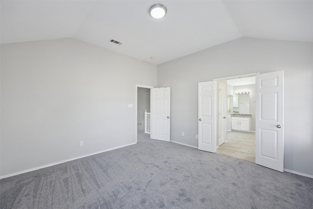 1153 Regal Dr, Garland, TX 75040 - unfurnished bedroom with lofted ceiling, light carpet, baseboards, and ensuite bathroom