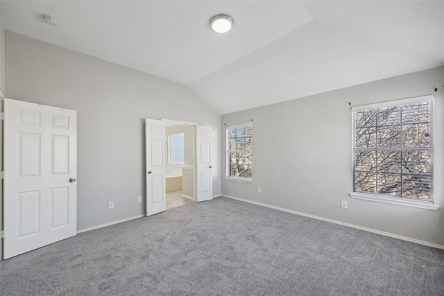 1153 Regal Dr, Garland, TX 75040 - unfurnished bedroom with carpet floors, lofted ceiling, baseboards, and ensuite bath