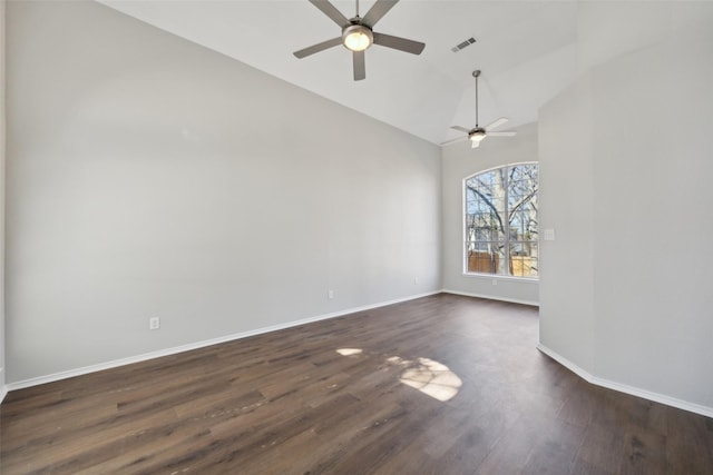 spare room featuring dark wood finished floors, visible vents, vaulted ceiling, ceiling fan, and baseboards