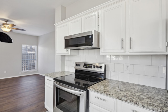 1153 Regal Dr, Garland, TX 75040 - kitchen with appliances with stainless steel finishes, dark wood-style flooring, decorative backsplash, baseboards, and white cabinets
