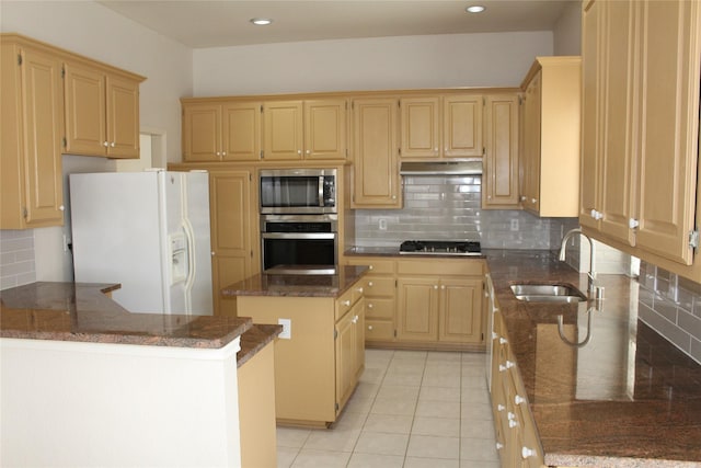 8509 Mustang Dr, Irving, TX 75063 - kitchen featuring a kitchen island, under cabinet range hood, dark stone counters, stainless steel appliances, and a sink