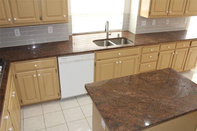 8509 Mustang Dr, Irving, TX 75063 - kitchen featuring dark stone countertops, light tile patterned flooring, white dishwasher, a sink, and backsplash