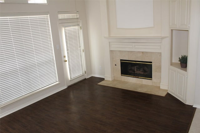 8509 Mustang Dr, Irving, TX 75063 - unfurnished living room featuring baseboards, dark wood-style flooring, and a tile fireplace