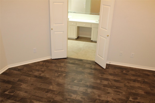 8509 Mustang Dr, Irving, TX 75063 - spare room with dark wood-style floors, built in desk, and baseboards