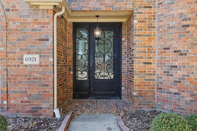 view of exterior entry with brick siding