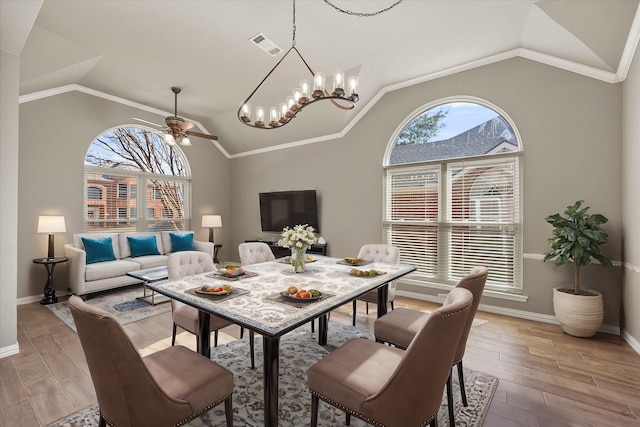 dining room featuring light wood finished floors, visible vents, baseboards, ceiling fan, and crown molding