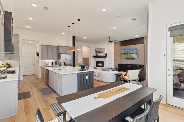 kitchen with visible vents, light countertops, gray cabinets, a ceiling fan, and stainless steel appliances