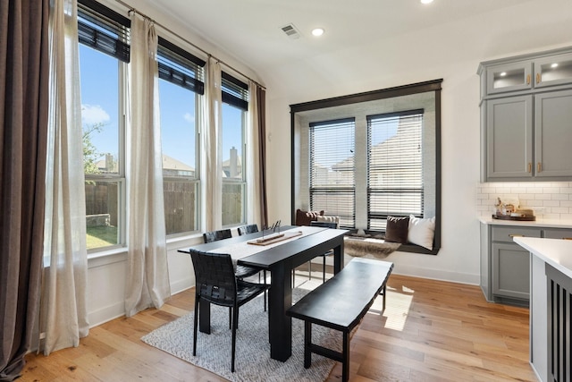 dining space with a wealth of natural light, baseboards, visible vents, and light wood finished floors