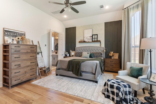 bedroom with ceiling fan, visible vents, light wood-style flooring, and vaulted ceiling