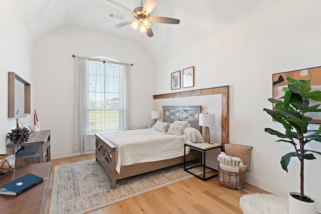 bedroom with light wood finished floors, baseboards, visible vents, a ceiling fan, and lofted ceiling