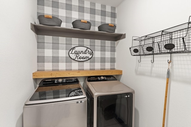 clothes washing area with laundry area, washer and clothes dryer, and wallpapered walls