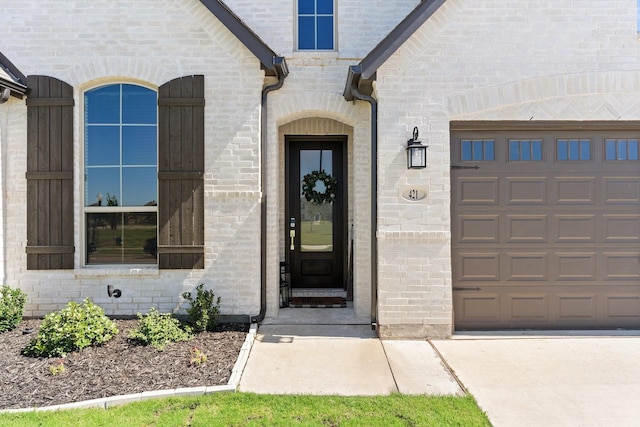 property entrance featuring brick siding and an attached garage