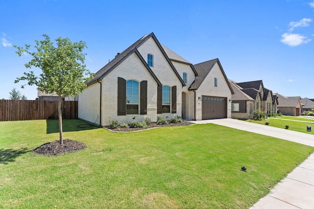 view of front facade with driveway, a front yard, brick siding, fence, and an attached garage