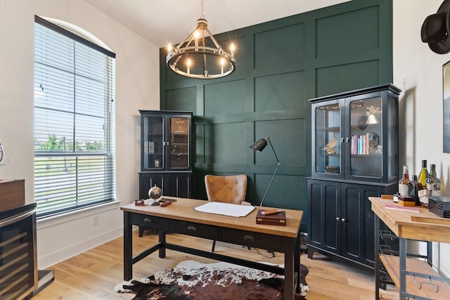 home office with a decorative wall, a chandelier, light wood-type flooring, wine cooler, and vaulted ceiling