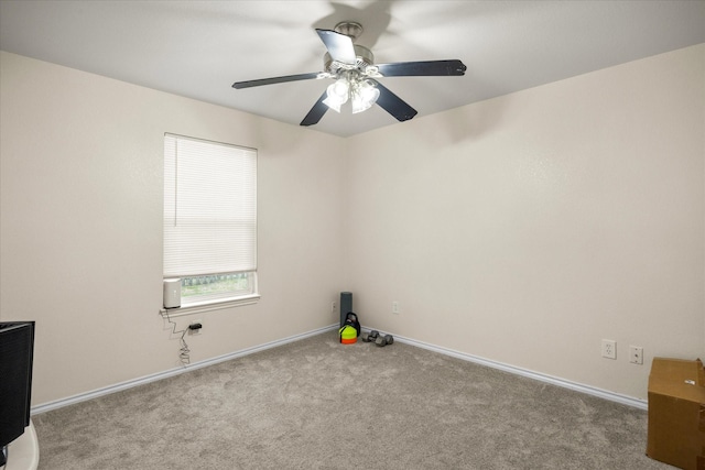 carpeted spare room with baseboards and a ceiling fan