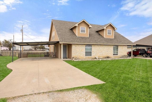 view of front of home with stone siding, concrete driveway, fence, and a front lawn