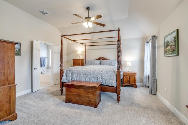 bedroom with light colored carpet, visible vents, ensuite bathroom, vaulted ceiling, and baseboards