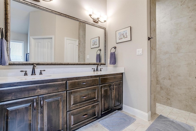 bathroom with double vanity, baseboards, walk in shower, and a sink