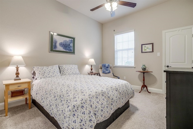 bedroom featuring light carpet, ceiling fan, and baseboards