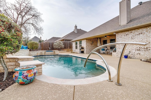 view of pool with a patio area, fence, a fenced in pool, and an in ground hot tub