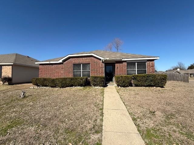 ranch-style house featuring brick siding and fence