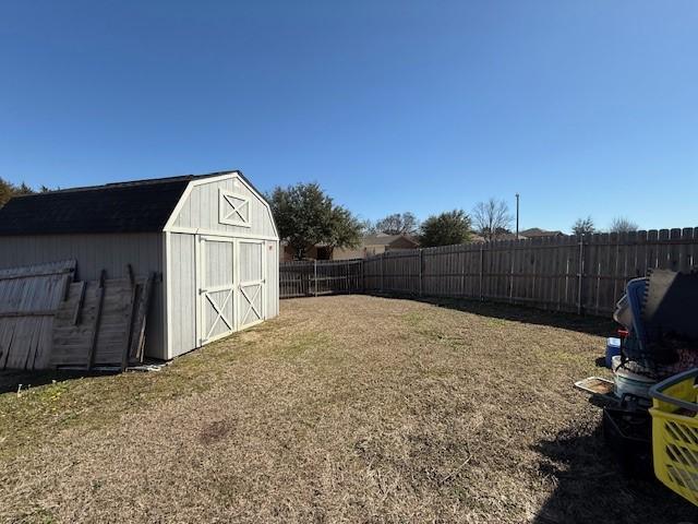 view of yard with a storage shed, an outdoor structure, and a fenced backyard