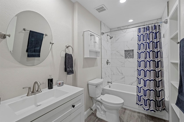 bathroom featuring shower / bath combo, visible vents, toilet, wood finished floors, and vanity