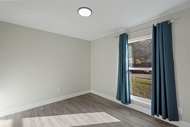 unfurnished room featuring wood tiled floor and baseboards