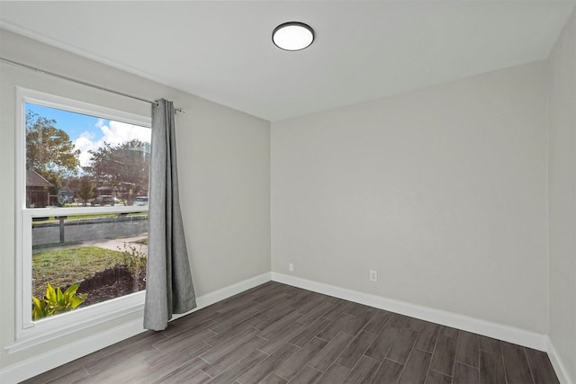 spare room with wood finish floors and baseboards