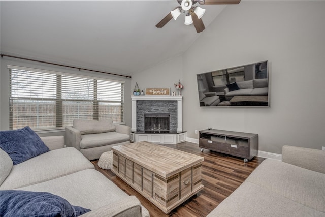 living room featuring ceiling fan, baseboards, lofted ceiling, a fireplace, and dark wood-style flooring