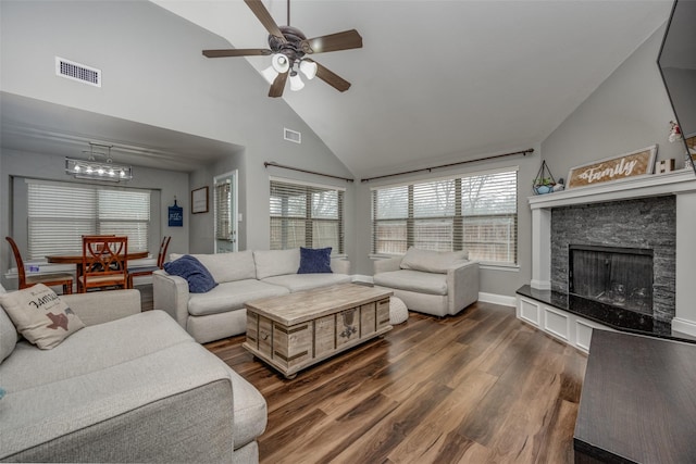 living area featuring visible vents, dark wood finished floors, a fireplace, high vaulted ceiling, and a ceiling fan