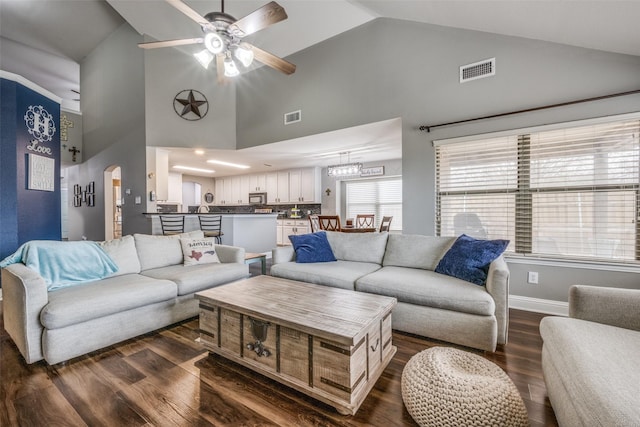 living area featuring arched walkways, visible vents, high vaulted ceiling, and dark wood-style floors