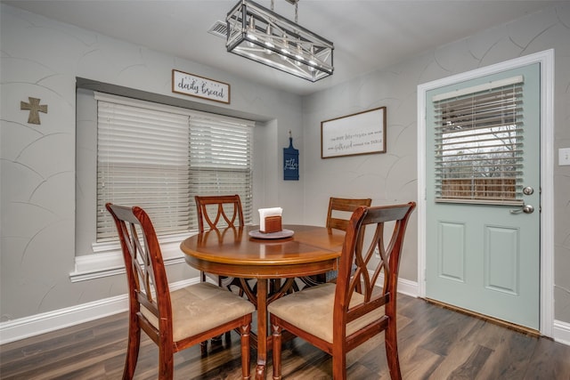 dining space with baseboards and dark wood-type flooring