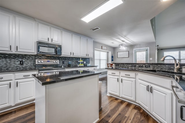 kitchen featuring visible vents, appliances with stainless steel finishes, dark wood-style floors, white cabinets, and a sink